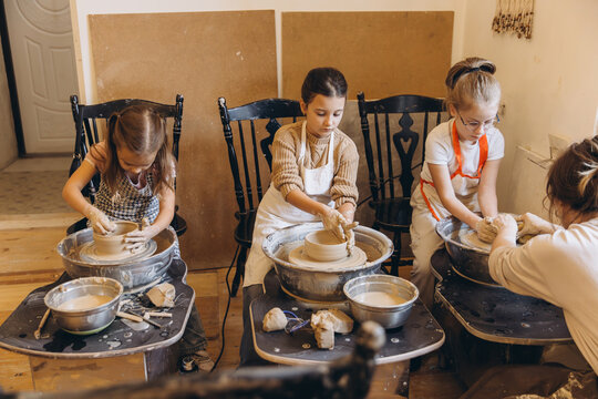 Children learning pottery skills in creative studio workshop