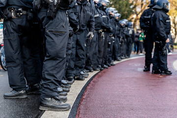 German Police officers with black boots standing in a row on the side of a demonstration or rally