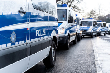 Riot police cars are standing on the side of a political rally or demonstration against the corona laws of the german government. © Ben D.