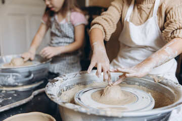 Children learning pottery craft on a spinning wheel