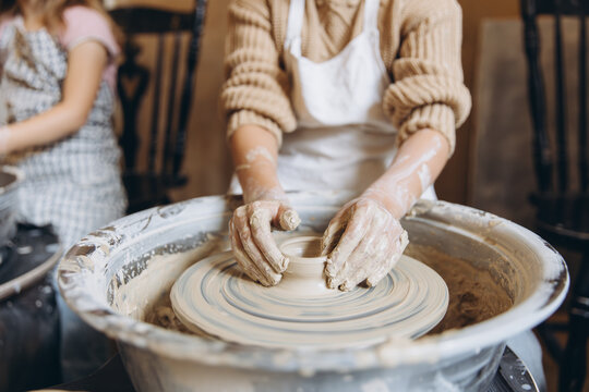 Child learning pottery using potter's wheel - Powered by Adobe