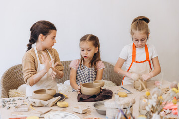 Children learning pottery skills in a creative workshop