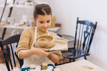 Young girl holding self made pottery clay creation