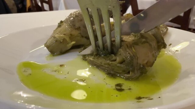 Artichoke on a plate, Italian appetizer Marinated grilled artichokes rotating on black background. Canned artichokes in oil. Pickled artichoke in marinade