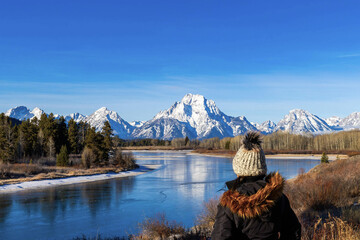 Woman admiring view of Mount Moran at Grand Teton National Park from Oxbow Bend with Sun Spikes