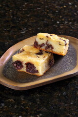 Mochi cake made with sweet rice flour (mochiko), sugar, baking powder, butter, milk, eggs, lemon extract, vanilla, and shredded coconut.
