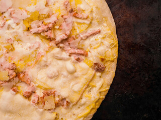 German pizza style dish with ham, potato, cheese and creamy sauce on a metal tray. Popular and tasty dish. Simple dinner.