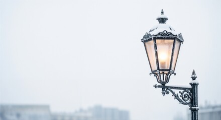 Vintage street lamp covered with snow during winter on gray background with copy space