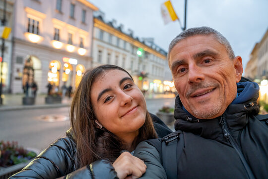 Father and daughter walking along a street in Warsaw enjoying sightseeing and urban atmosphere