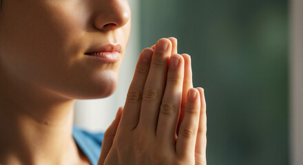 Young woman praying with clasped hands and contemplative expression