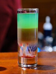 Vibrant layers of colorful shots display a creative mixology masterpiece. Each glass captures light beautifully while showcasing a spectrum of colors, igniting excitement in lively bar atmosphere.