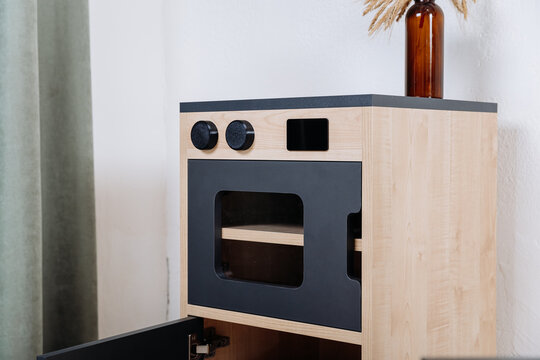 Wooden toy oven close up from a kids play kitchen, minimal Nordic design for nursery