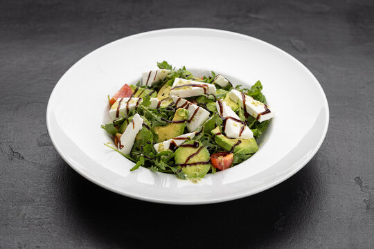 Fresh avocado and feta salad with arugula, cherry tomatoes and balsamic drizzle - Powered by Adobe