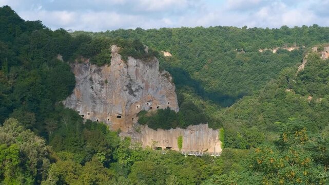 Necropolis of san giuliano carved in tuff rock cliff. Aerial view panning over the ancient etruscan necropolis of san giuliano, a fascinating archaeological site with tombs carved into the tuff cliff