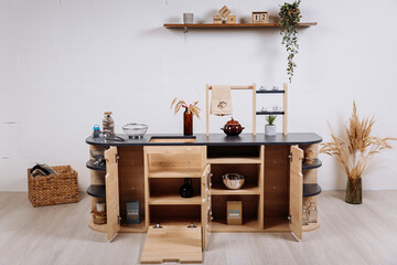 Wooden kids play kitchen with shelves and accessories in minimalist nursery interior