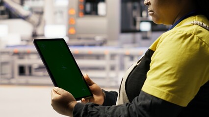 Close up of green screen tablet used by engineer in factory to perform maintenance, analyzing IoT sensors data. Industrial plant worker managing photovoltaic systems using chroma key device, camera B