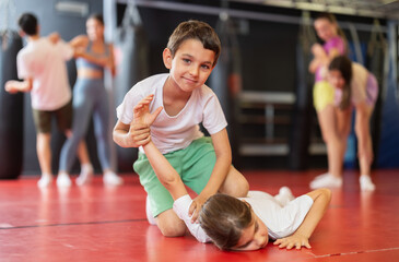Naklejka premium Boy and girl training self-defense techniques in pairs in studio