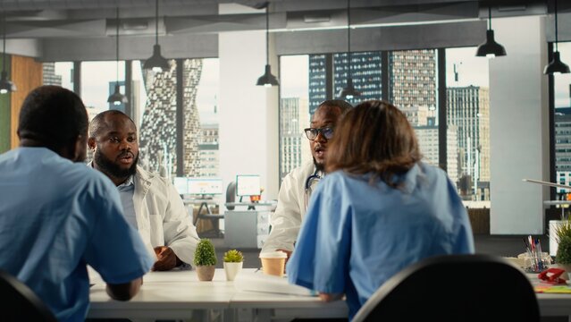 Diverse physicians team reviewing clinical records and working together to share expertise and diagnostic results to improve healthcare services at the hospital. Brainstorm treatment ideas.