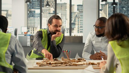 Developers and architects working on real estate investment plan. Business team analyzes property data, housing blueprints and market trends to optimize land acquisition and projects.