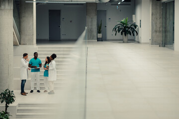 Diverse medical team discussing in modern hospital lobby