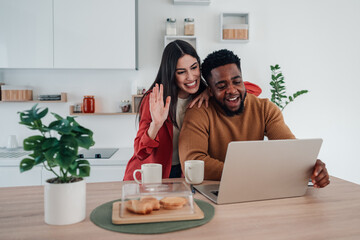 Happy interracial couple enjoying video call at home