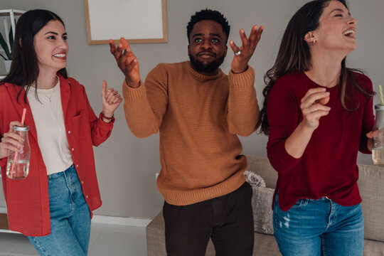 Diverse friends dancing together at home party