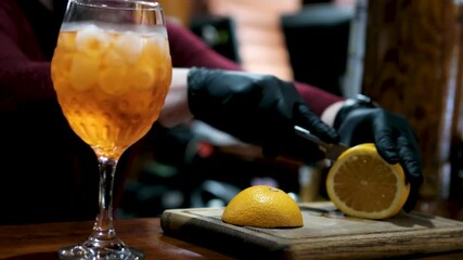 Bartender Slicing Oranges And Lemons Preparing Citrus Cocktail Drink. Aperol in a glass preparation