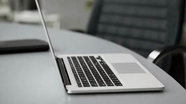 Person holding USB drive near laptop, notebook, pen on table