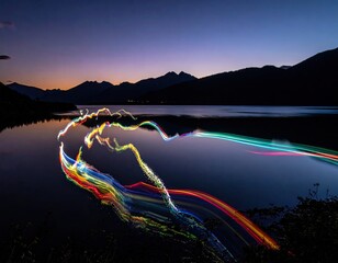 Light trails dance on still lake, mountains in the background