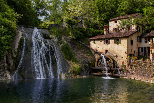 Old water mill in the river in Refrontolo, Veneto, Italy, Molinetto della Croda, panorama with a beautiful waterfall in the woods, no people.