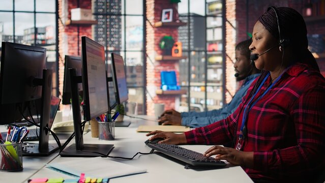 Team of call center agents tracking shipments in office, handling delivery delays. Customer center coworkers use software to locate clients packages and provide status updates, camera B