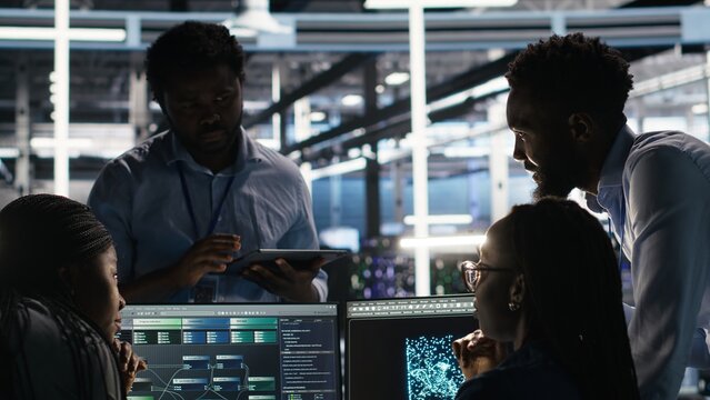 Data center coworkers doing brainstorming, using node tree software to analyze datasets. Server room teamworking colleagues using visual programming tools to improve gear performance, camera B