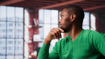 Black teleworker being pensive thinking about solutions to make more money, using his creativity and innovation for development. Young adult looking for new smart ideas. Camera A.