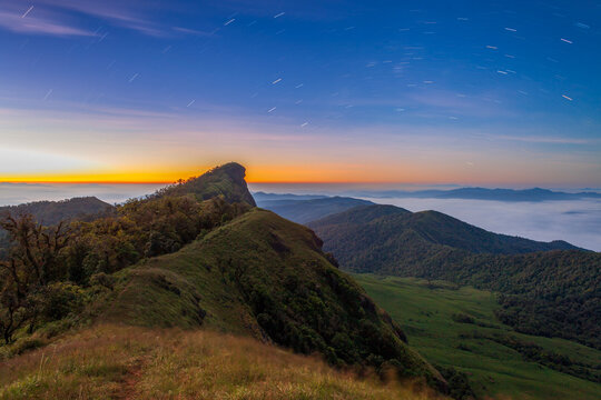 Doi Mon Jong mountain ridge trail at golden hour with misty landscape in Chiang Mai Thailand. Popular trekking destination showing scenic mountain path and sunset view