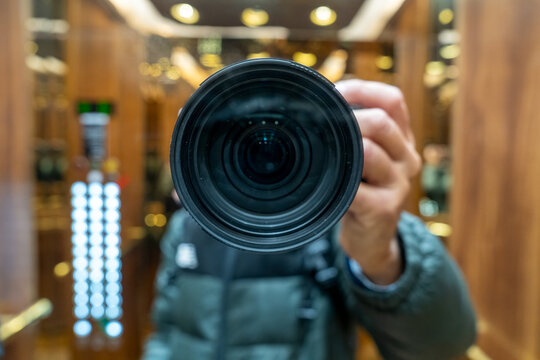 Urban photography of photographer using elevator mirrors to frame artistic reflections and symmetry