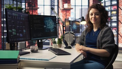 Female IT engineer doing maintenance on artificial intelligence systems, sitting at office desk. Young woman works as developer with cybernetics and algorithms for machine learning. Camera A.