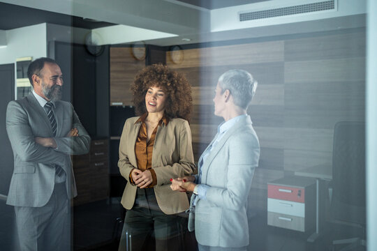 Business colleagues having informal discussion in modern office