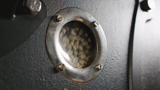 Close-up view of coffee beans roasting inside a machine showcasing the transformation process in a local roastery
