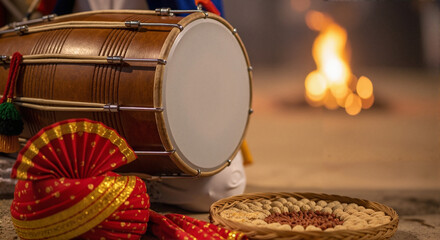 Colorful turban and musical drum beside roasted peanuts and fire  