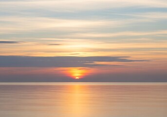 Tranquil seascape illuminated by the radiant glow of the setting sun