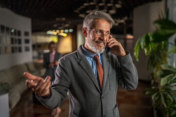Mature businessman making phone call discussing corporate strategy