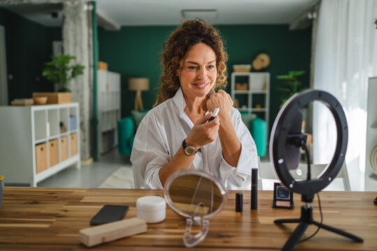 Woman v-logger trying on makeup for beauty tutorial - Powered by Adobe