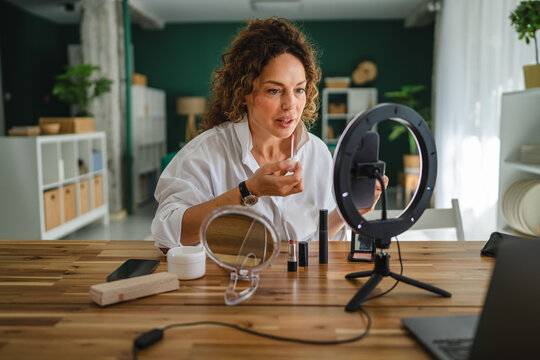 Woman beauty influencer applying makeup creating content online