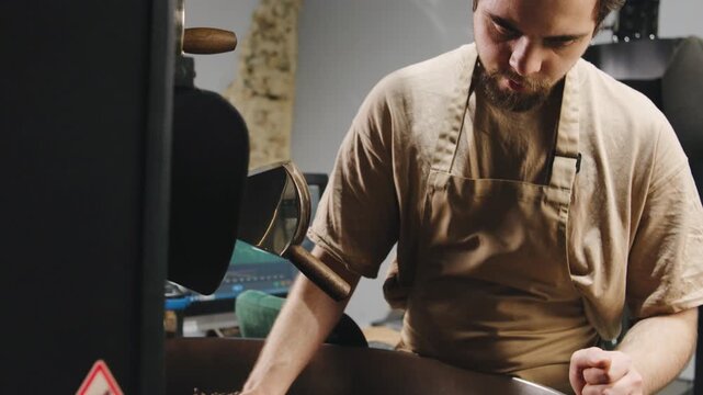 Artisan roaster skillfully prepares fresh coffee beans in a cozy roasting space during the afternoon hours