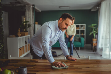 Couple cleaning home, sharing housework and domestic chores