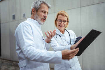 Medical team collaborating and discussing patient data outdoors