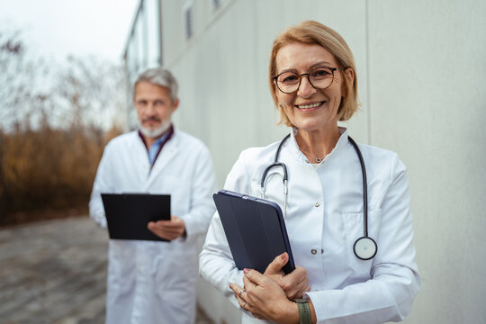 Mature female doctor reviewing medical information on digital tablet