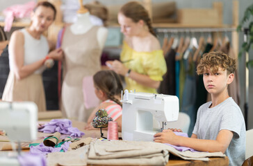 Portrait of happy teenage boy at sewing class