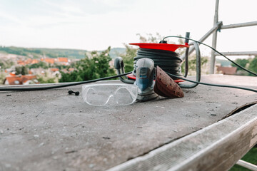 Construction and renovation.Sanding Tools and Safety Glasses on Work Surface. grinding machine,...