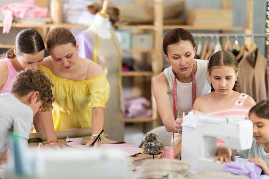 Group of children draw dress pattern, perform blanks from paper to create dresses, school for young fashion designers and tailors...